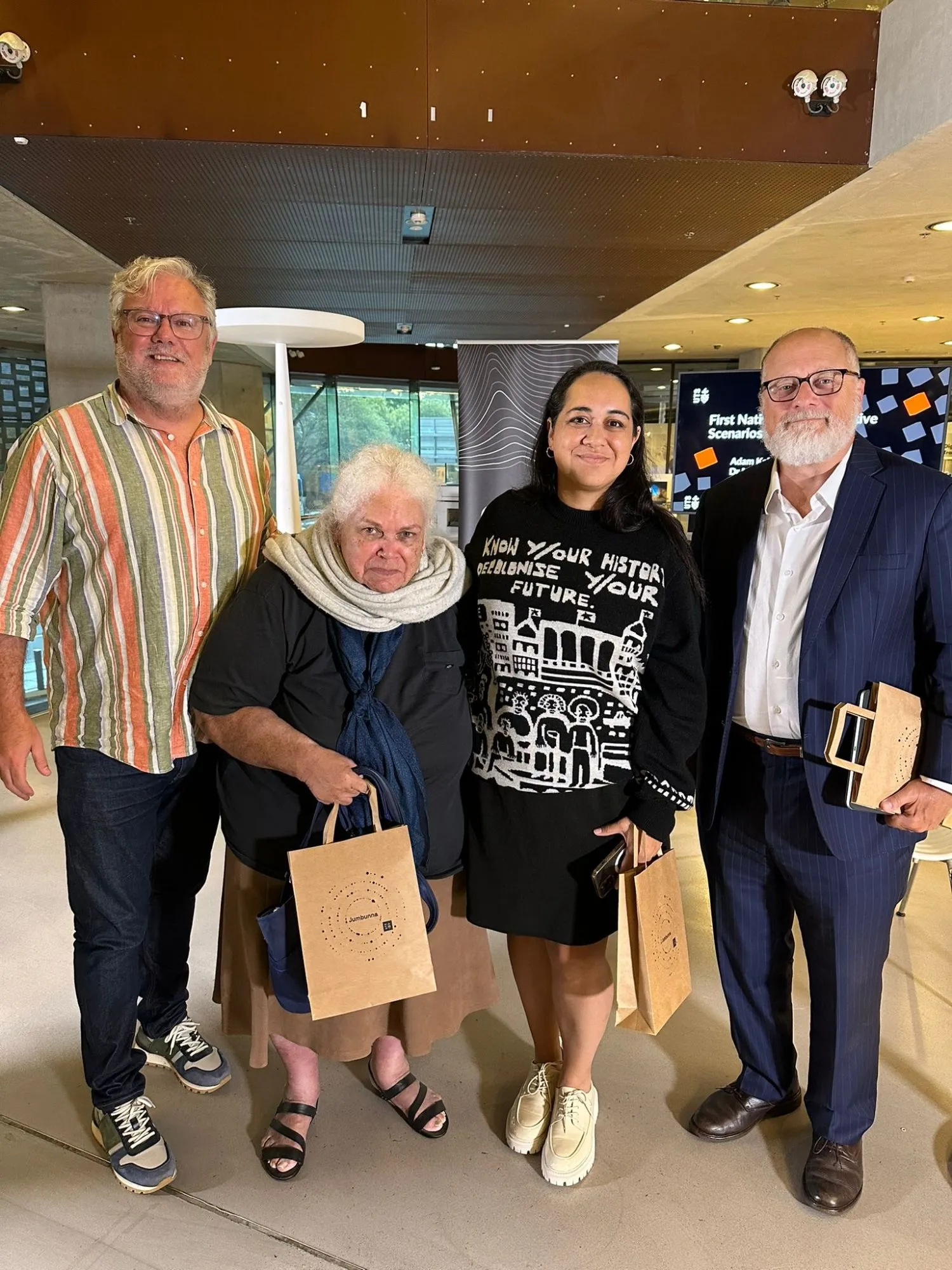 Four people standing together at a First Nations transformative scenarios event at Jumbunna, UTS